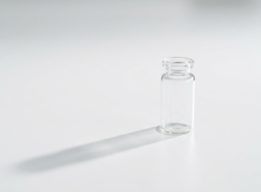 HHS vaccine recommendations concept, single glass vial on a sterile white surface
