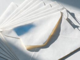 Supreme Court mail voting concept, macro of fanned blank white envelopes with one out of line