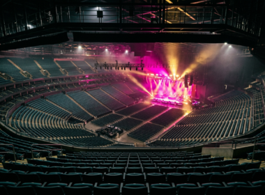 Live Nation settlement concept, empty arena from the top row with the stage lit magenta and gold