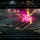 Live Nation settlement concept, empty arena from the top row with the stage lit magenta and gold