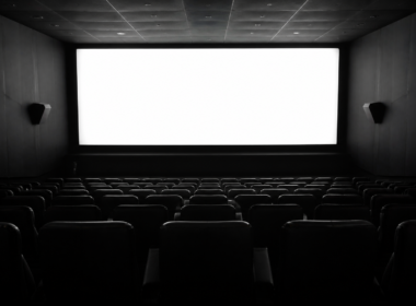 You Maniac series concept: empty cinema seats facing a bright glowing screen