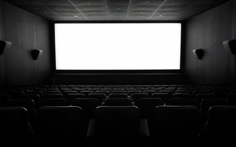 You Maniac series concept: empty cinema seats facing a bright glowing screen