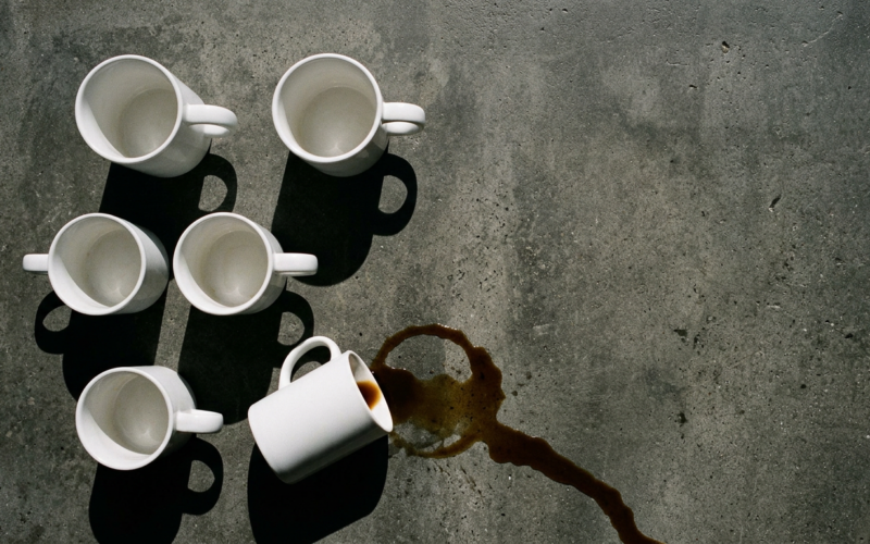 Big Brother 28 spoilers illustrated by three upright white mugs on concrete with a fourth tipped and spilling