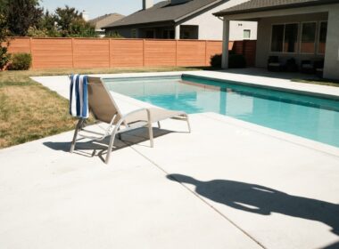 Big Brother 28 spoilers illustrated by an empty pool lounger on a sunlit patio with a towel over the arm
